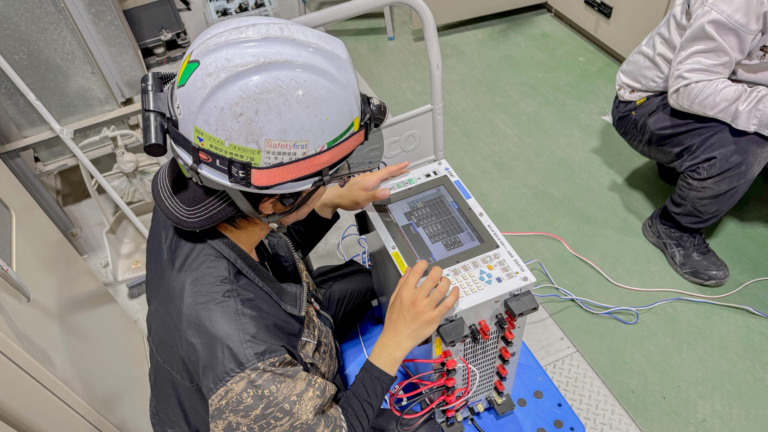 保護継電器試験で、機器を繋いで操作する様子