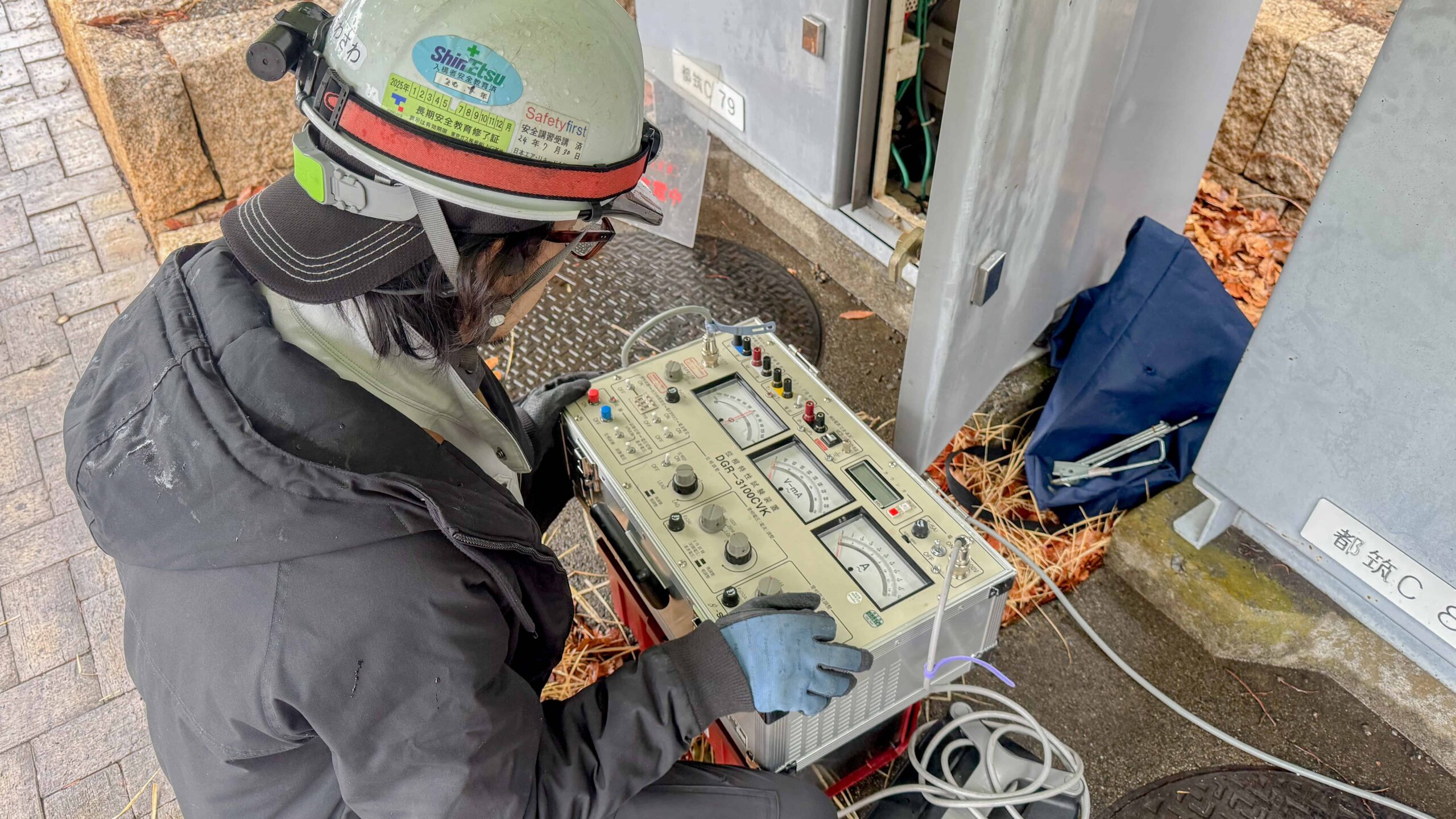 保護継電器試験で、機器を繋いで作業する作業員の様子